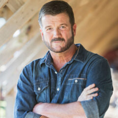Middle-aged man in denim shirt, arms crossed